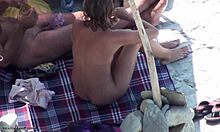 रंगों में अच्छी दिखने वाली भूरी बालों वाली लड़की एक न्यूडिस्ट बीच पर अपना नग्न शरीर दिखा रही है।